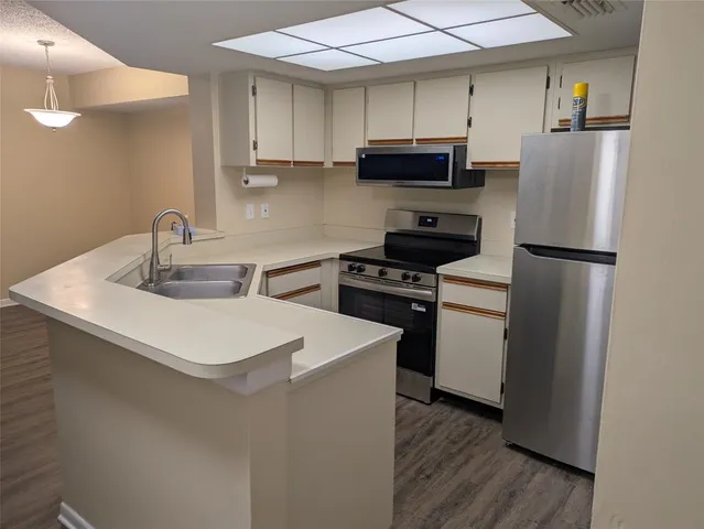 a kitchen with a sink a refrigerator and cabinets