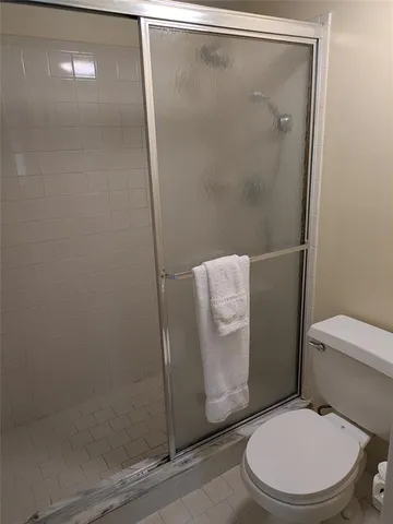 a white toilet sitting next to a shower