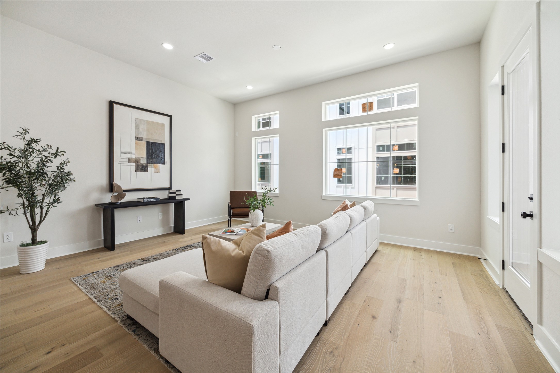 3911 Tulane Street, Unit B Houston, TX 77018 - Photo 11 of 37 Bright and inviting living room with large windows, modern decor, and beautiful wood floors—perfect for relaxation and entertaining.