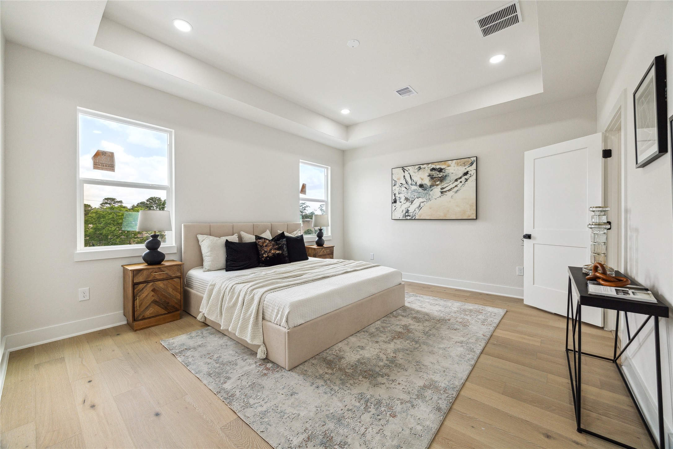 3911 Tulane Street, Unit B Houston, TX 77018 - Photo 15 of 37 Experience serene comfort in this spacious primary bedroom, featuring abundant natural light, elegant tray ceilings, and stylish decor. Perfect for relaxation and rejuvenation.