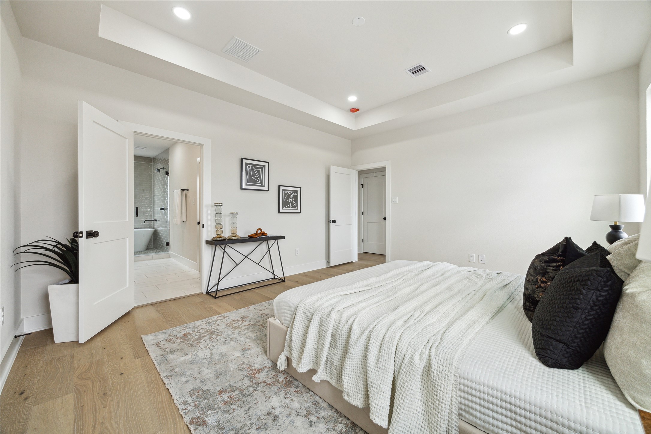 3911 Tulane Street, Unit B Houston, TX 77018 - Photo 16 of 37 Experience luxury in this spacious primary bedroom, featuring a serene color palette, elegant tray ceiling, and an ensuite bathroom for ultimate comfort.