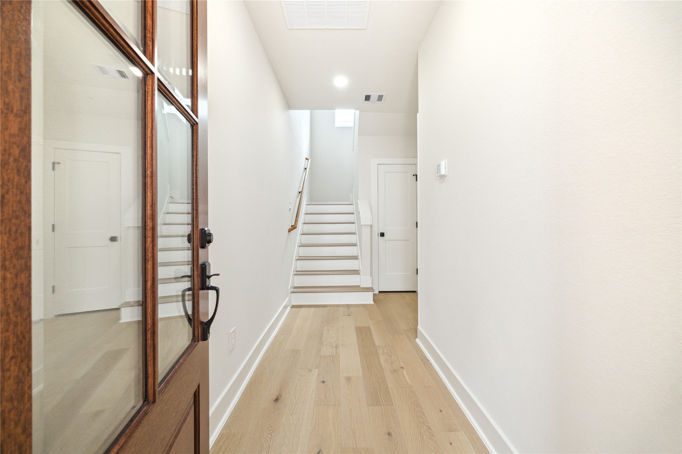 3911 Tulane Street, Unit B Houston, TX 77018 - Photo 29 of 37 Step into a bright and welcoming entrance, featuring elegant wood flooring and a modern, open staircase leading to your new home.