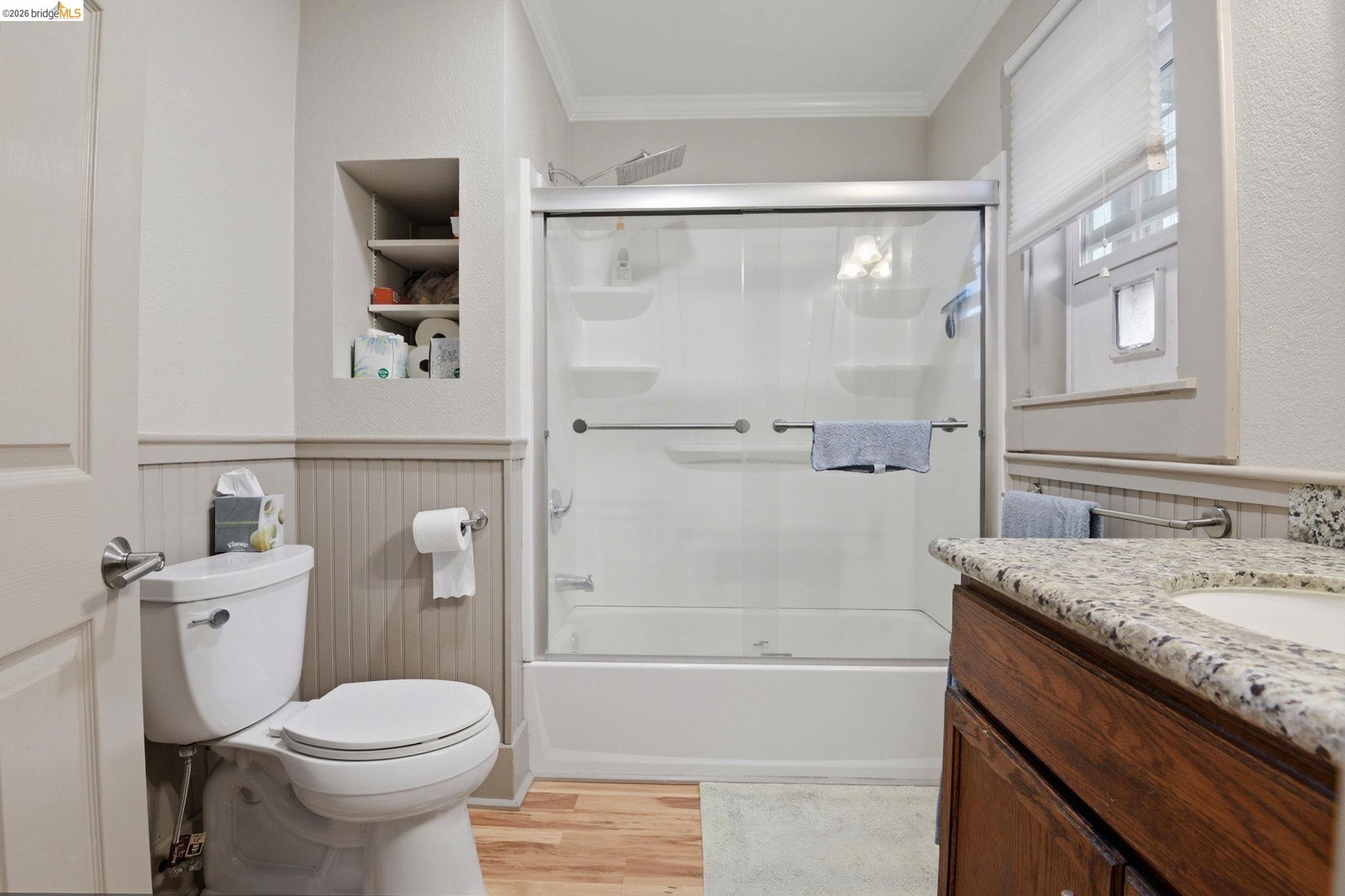 2155 Chestnut Street Livermore, CA 94551 - Photo 17 of 44 Full bath featuring vanity, crown molding, light wood-style floors, built in shelves, and combined bath / shower with glass door