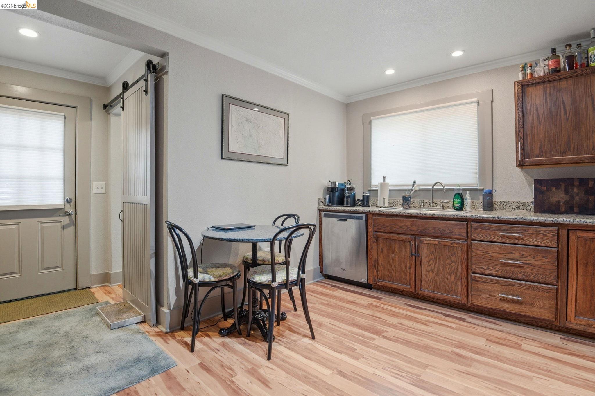 2155 Chestnut Street Livermore, CA 94551 - Photo 9 of 44 Kitchen with a barn door, stainless steel dishwasher, crown molding, light wood-style floors, and recessed lighting