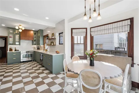 a large kitchen with a sink a stove a dining table and chairs