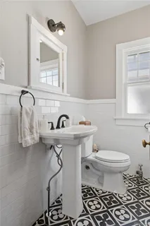 a bathroom with a sink a toilet and mirror