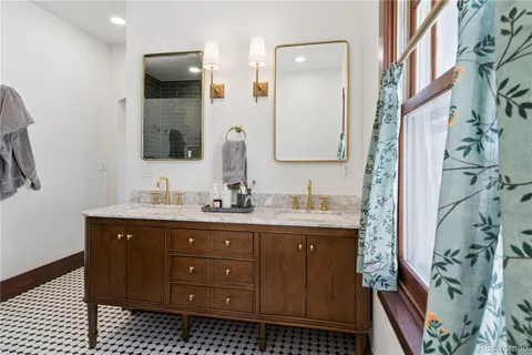 a bathroom with a granite countertop sink a mirror and shower