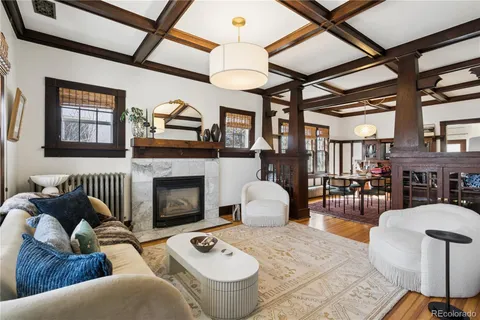 a living room with furniture a fireplace and wooden floor