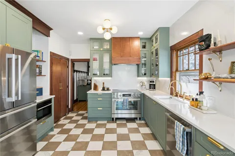 a kitchen with stainless steel appliances a sink a stove a refrigerator and cabinets