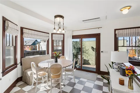 a dining room with furniture and large windows