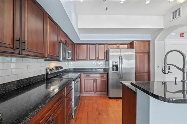 a kitchen with stainless steel appliances granite countertop a sink stove and refrigerator