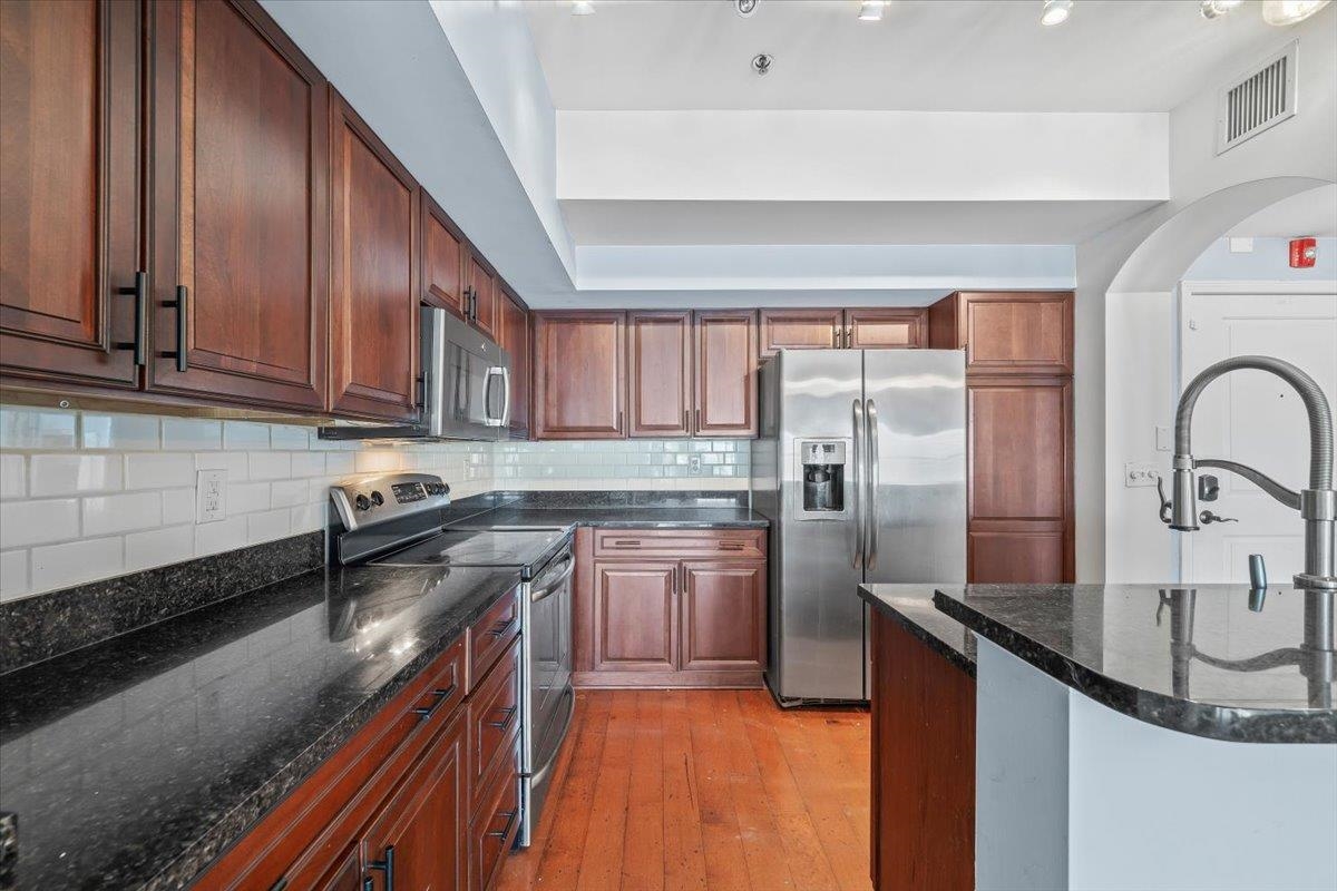 665 Tennessee Street, Unit 301 Memphis, TN 38103 - Photo 12 of 38 a kitchen with stainless steel appliances granite countertop a sink stove and refrigerator
