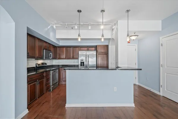 a kitchen with stainless steel appliances granite countertop a stove a sink and a refrigerator