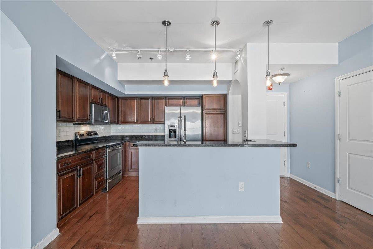 665 Tennessee Street, Unit 301 Memphis, TN 38103 - Photo 14 of 38 a kitchen with stainless steel appliances granite countertop a stove a sink and a refrigerator