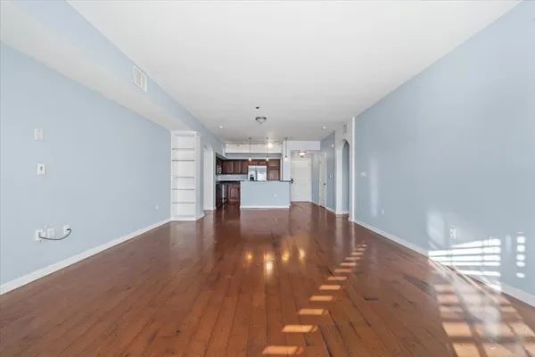 a view of a kitchen with wooden floor and a kitchen space