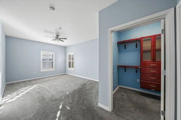 a view of an empty room with closet and cabinet