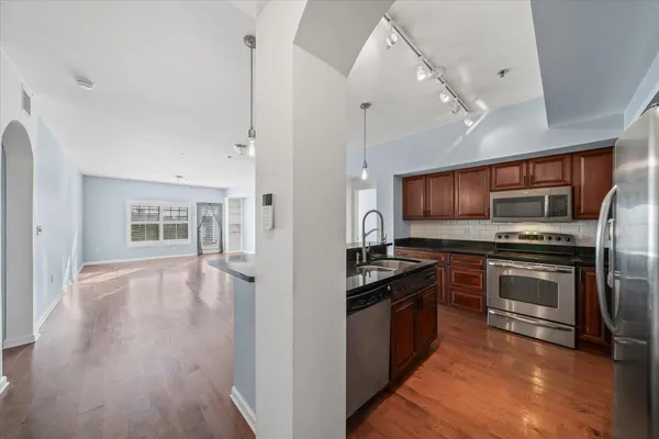 a kitchen with stainless steel appliances a stove top oven and a refrigerator