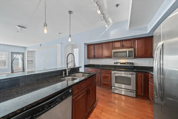 a kitchen with granite countertop stainless steel appliances and wooden cabinets