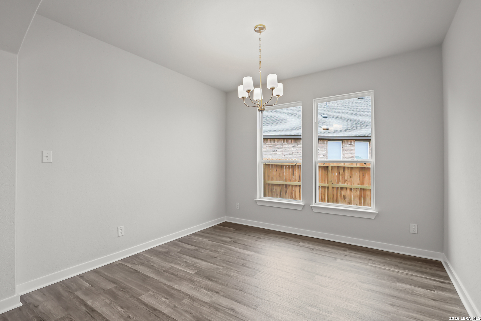 165 Mallorys Way Castroville, TX 78009 - Photo 13 of 34 wooden floor in an empty room with a window