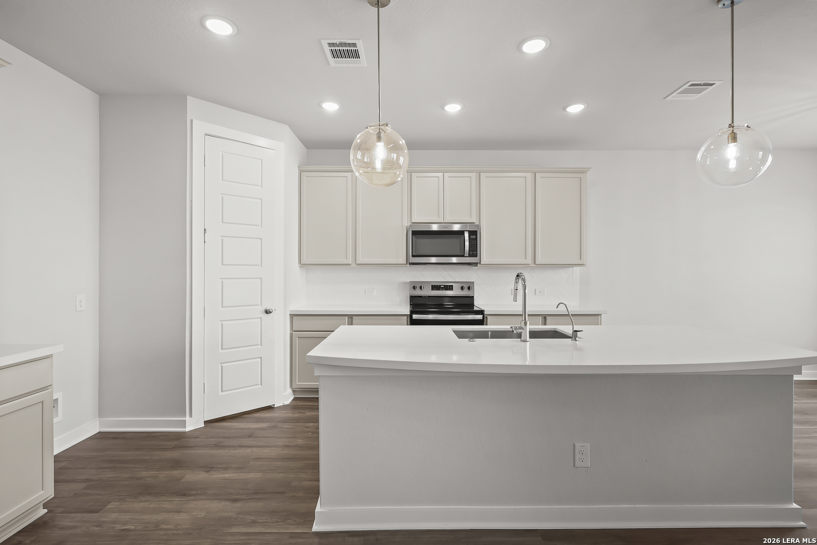 165 Mallorys Way Castroville, TX 78009 - Photo 8 of 34 a kitchen with kitchen island a sink stainless steel appliances and white cabinets