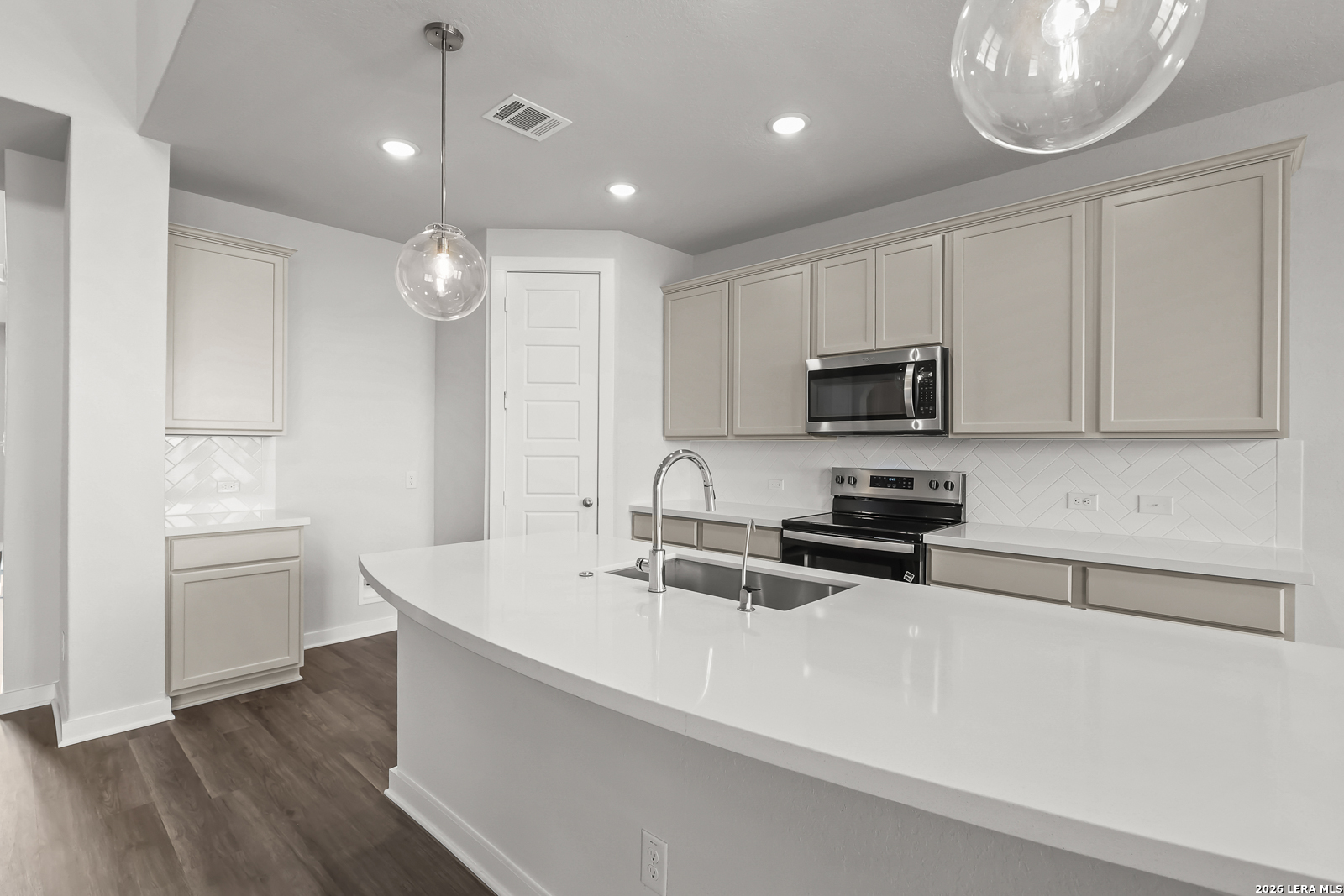 165 Mallorys Way Castroville, TX 78009 - Photo 9 of 34 a kitchen with stainless steel appliances a sink a stove a microwave and cabinets