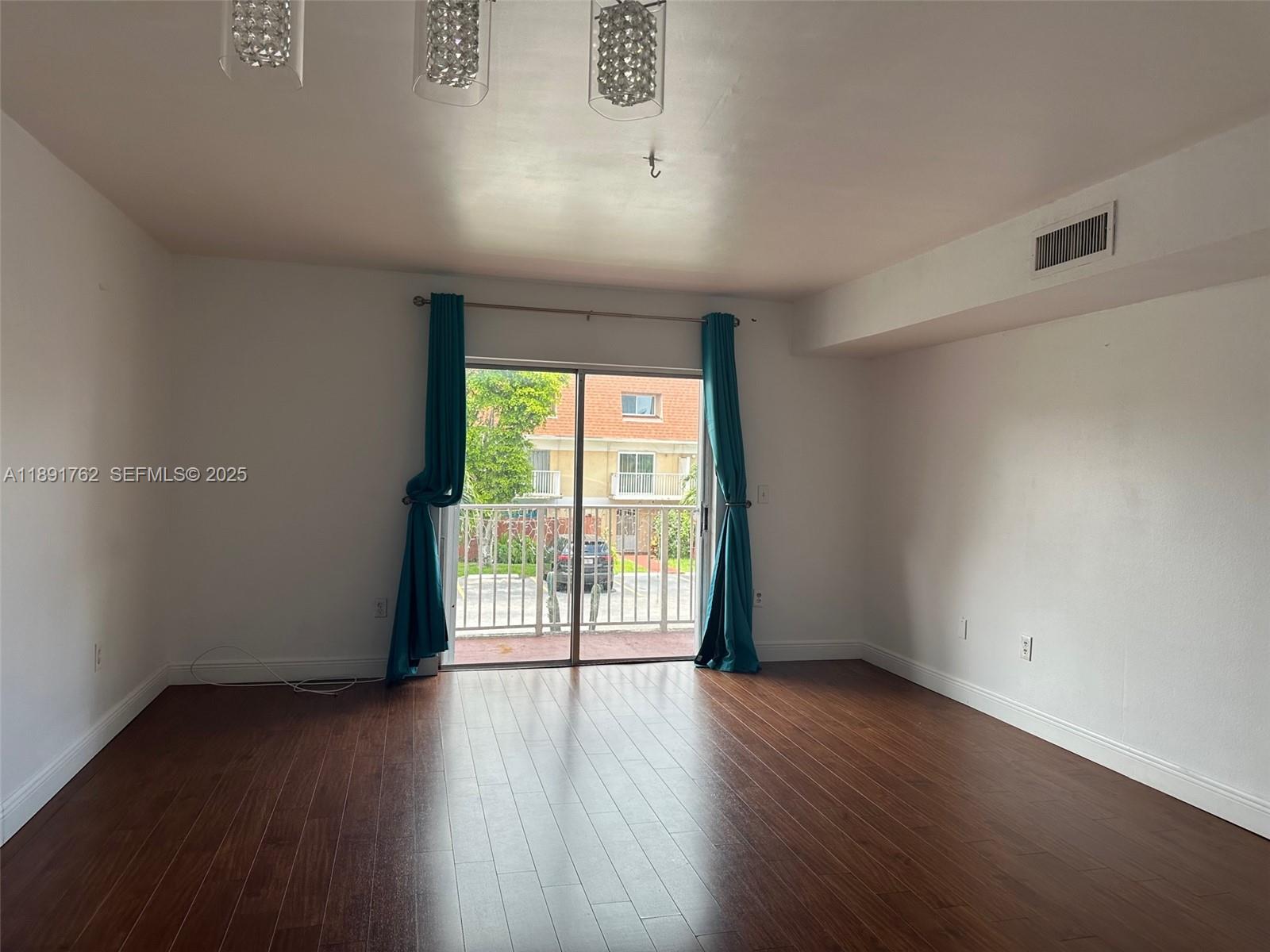 250 Northwest 107th Avenue, Unit 222 Miami, FL 33172 - Photo 5 of 10 an empty room with wooden floor and windows
