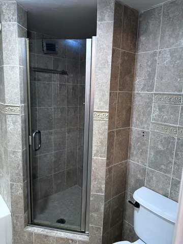 a bedroom with a bed and a refrigerator