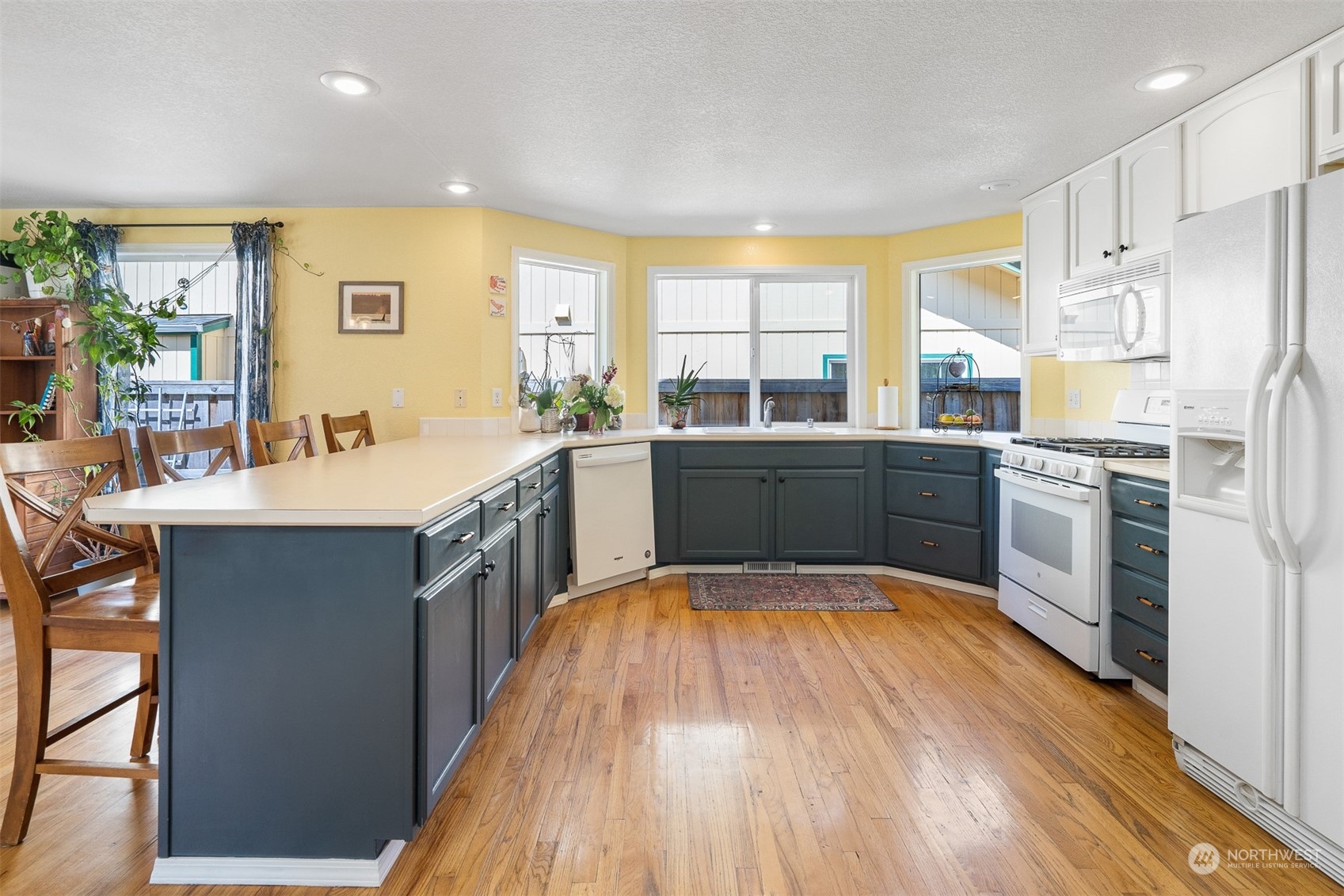 1765 53rd Loop Southeast Olympia, WA 98501 - Photo 13 of 34 a large kitchen with a large counter top a sink stainless steel appliances and cabinets