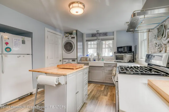 a kitchen with a sink a stove top oven and refrigerator