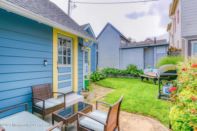 a view of a chair and table in backyard of the house