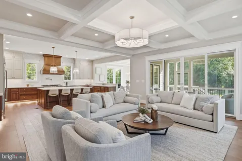 a living room with furniture kitchen and a chandelier
