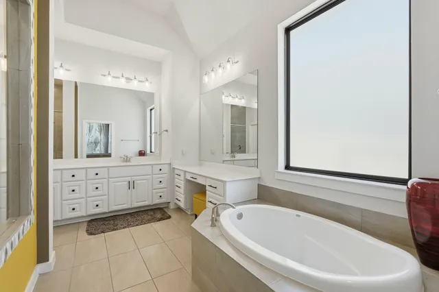 a spacious bathroom with a bathtub sink and mirror