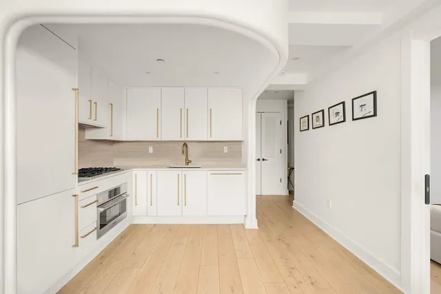 a kitchen with granite countertop white cabinets and white appliances