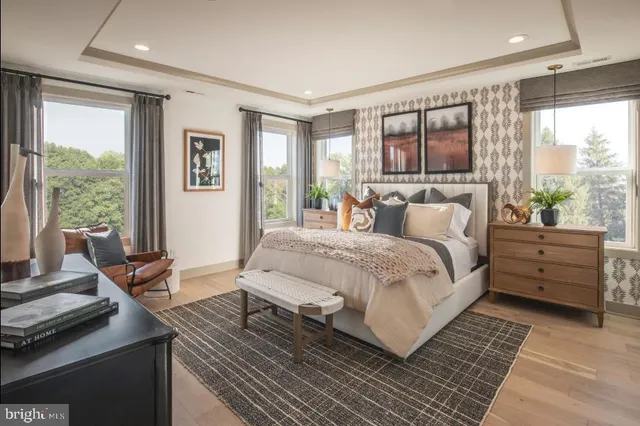 a bedroom with a bed and large windows