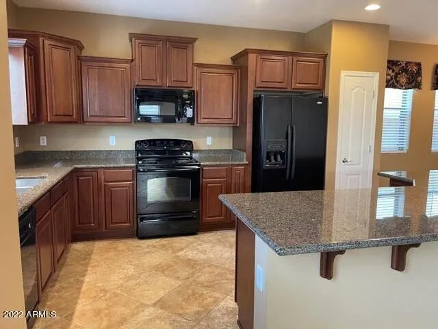 a kitchen with granite countertop a stove top oven and cabinets