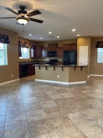 a view of a kitchen with kitchen island a sink wooden floor and a counter top space