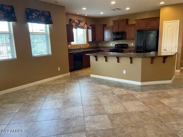 a kitchen with stainless steel appliances granite countertop a stove top oven a sink a counter top space cabinets and a window