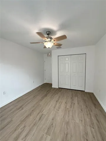a view of a livingroom with a ceiling fan & wooden floor