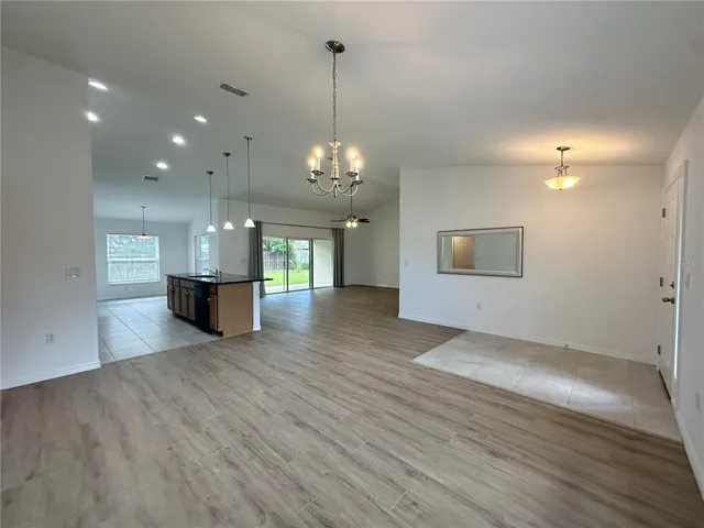 a view of a room with wooden floor kitchen and a sink