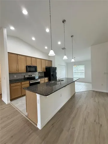 a large kitchen with kitchen island a sink counter space and stainless steel appliances