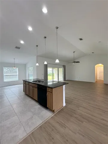 a kitchen with granite countertop a stove a sink and a wooden cabinets