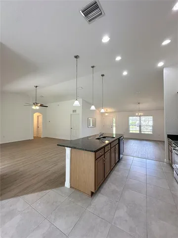 a kitchen with stainless steel appliances granite countertop a stove a sink and a refrigerator