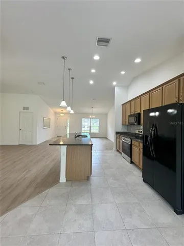 a large kitchen with a large counter top and stainless steel appliances