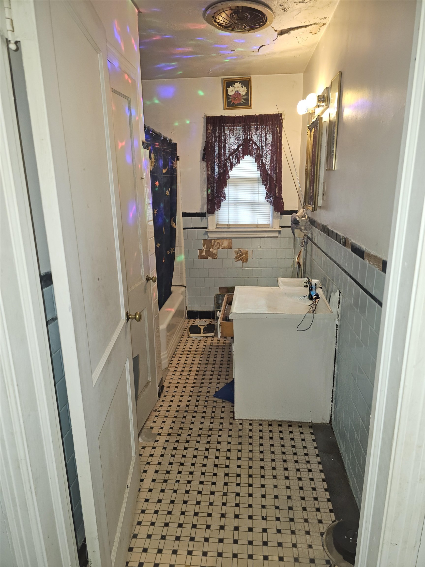 1515 Semmes Street Memphis, TN 38114 - Photo 9 of 9 Bathroom featuring black and white mosaic tile flooring, a white bathtub, and light blue wall tiling