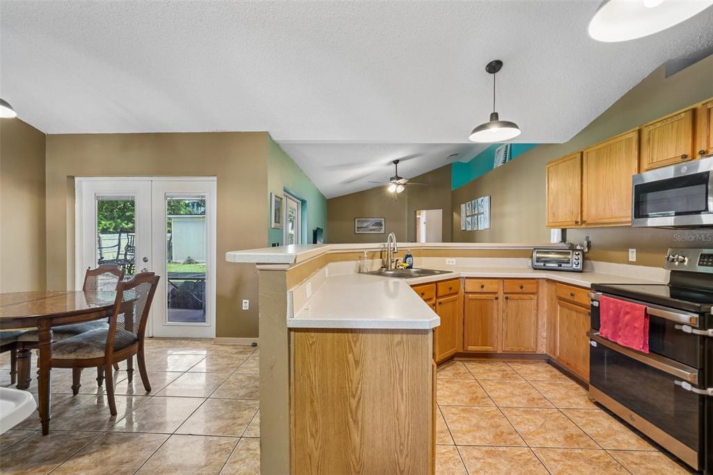 10303 Fordham Street Spring Hill, FL 34608 - Photo 5 of 25 a kitchen with stainless steel appliances granite countertop a sink a stove and a refrigerator