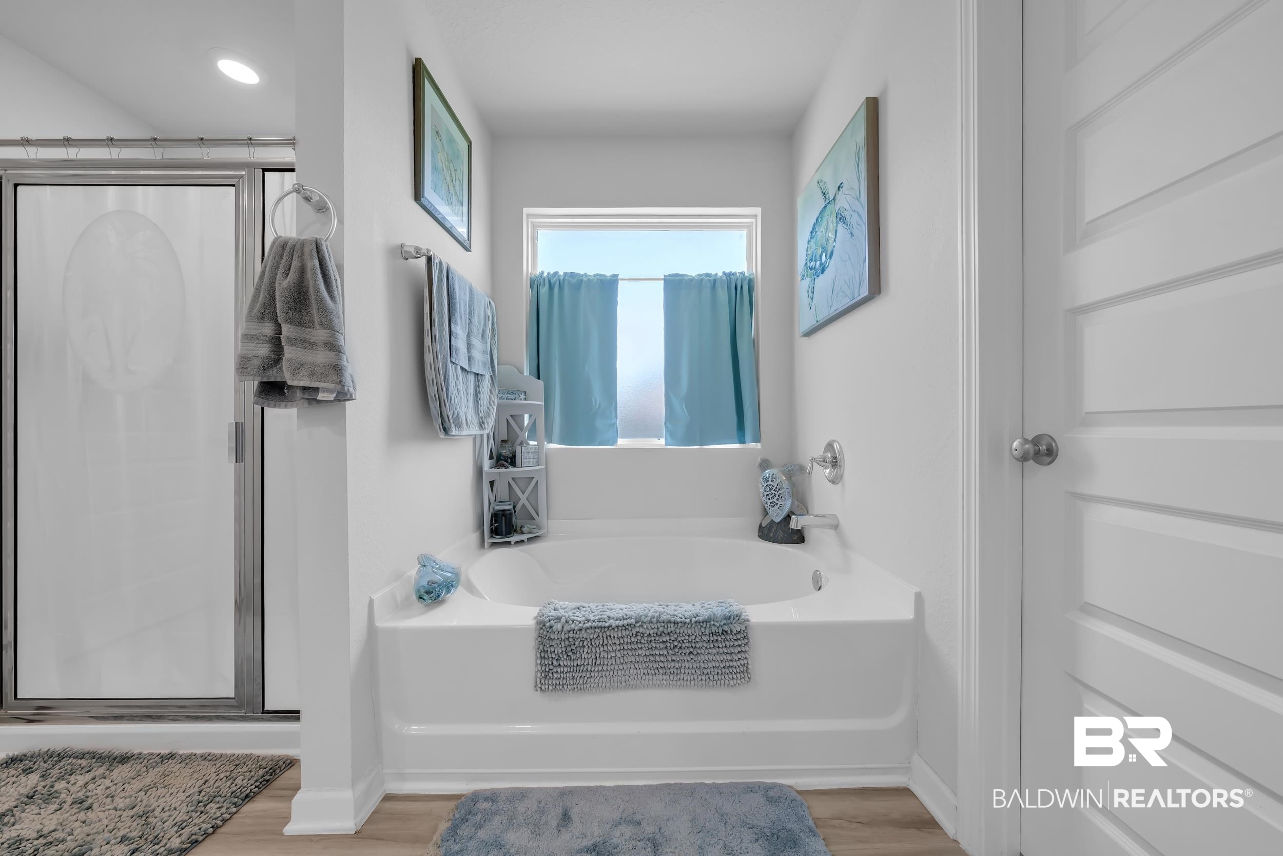 24271 Ringneck Loop Elberta, AL 36530 - Photo 25 of 44 Spacious bathroom featuring a built-in soaking tub, a separate shower with a glass enclosure, an overhead light fixture, and wood-finish flooring