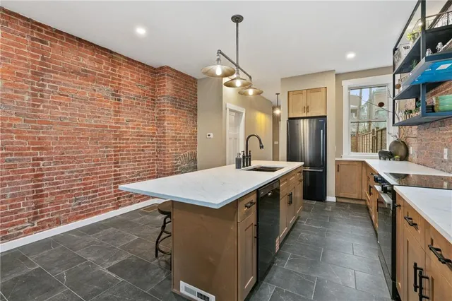 a kitchen with stainless steel appliances granite countertop a sink a counter space and cabinets