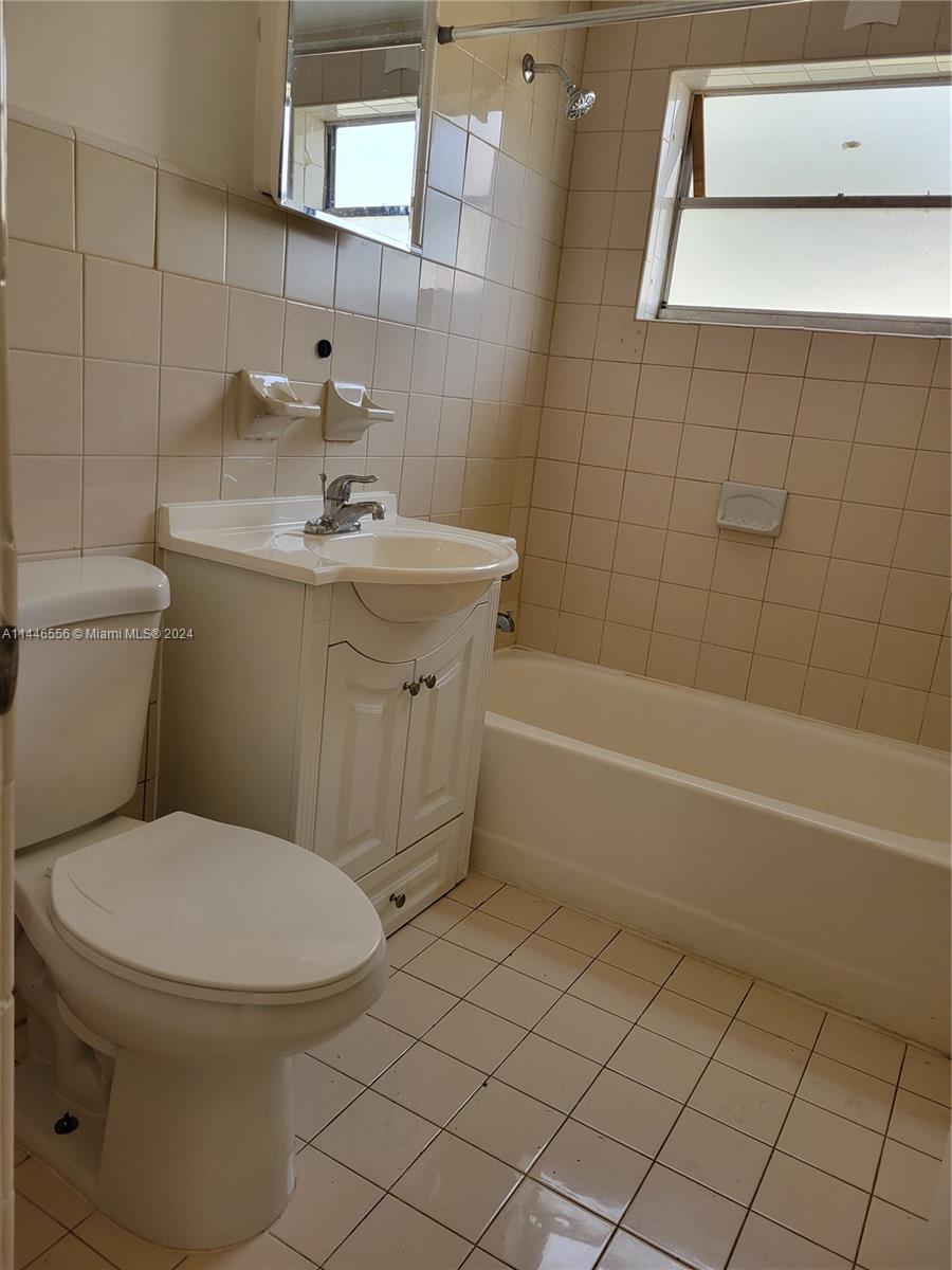 1755 Northeast 116th Road, Unit 9 North Miami, FL 33181 - Photo 16 of 27 a bathroom with a sink a toilet and shower