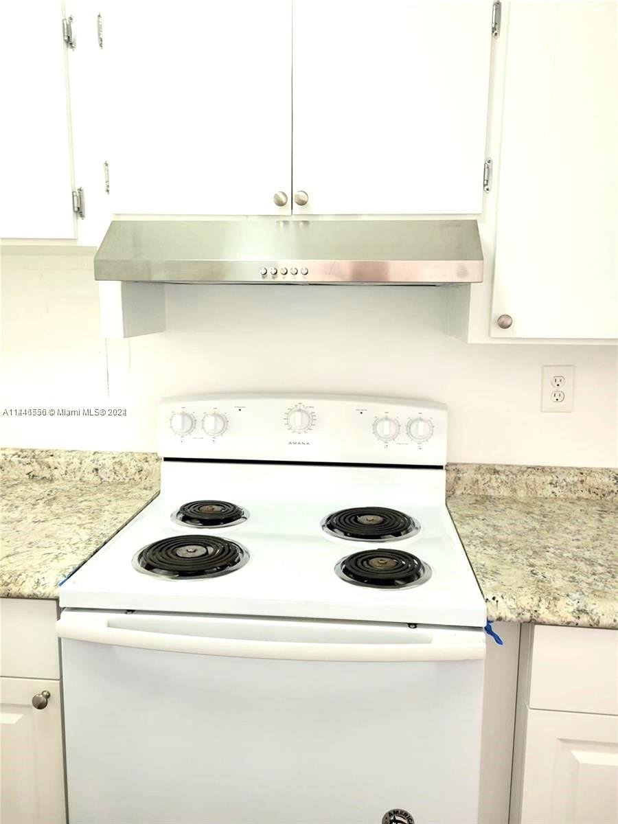 1755 Northeast 116th Road, Unit 9 North Miami, FL 33181 - Photo 22 of 27 a kitchen with a stove and a microwave