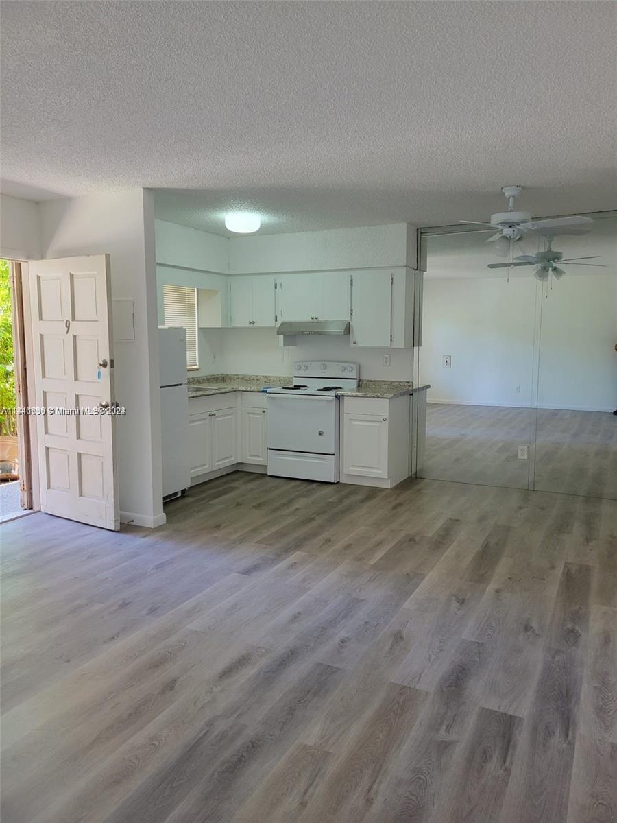 1755 Northeast 116th Road, Unit 9 North Miami, FL 33181 - Photo 3 of 27 a room with a wooden floor and white cabinets